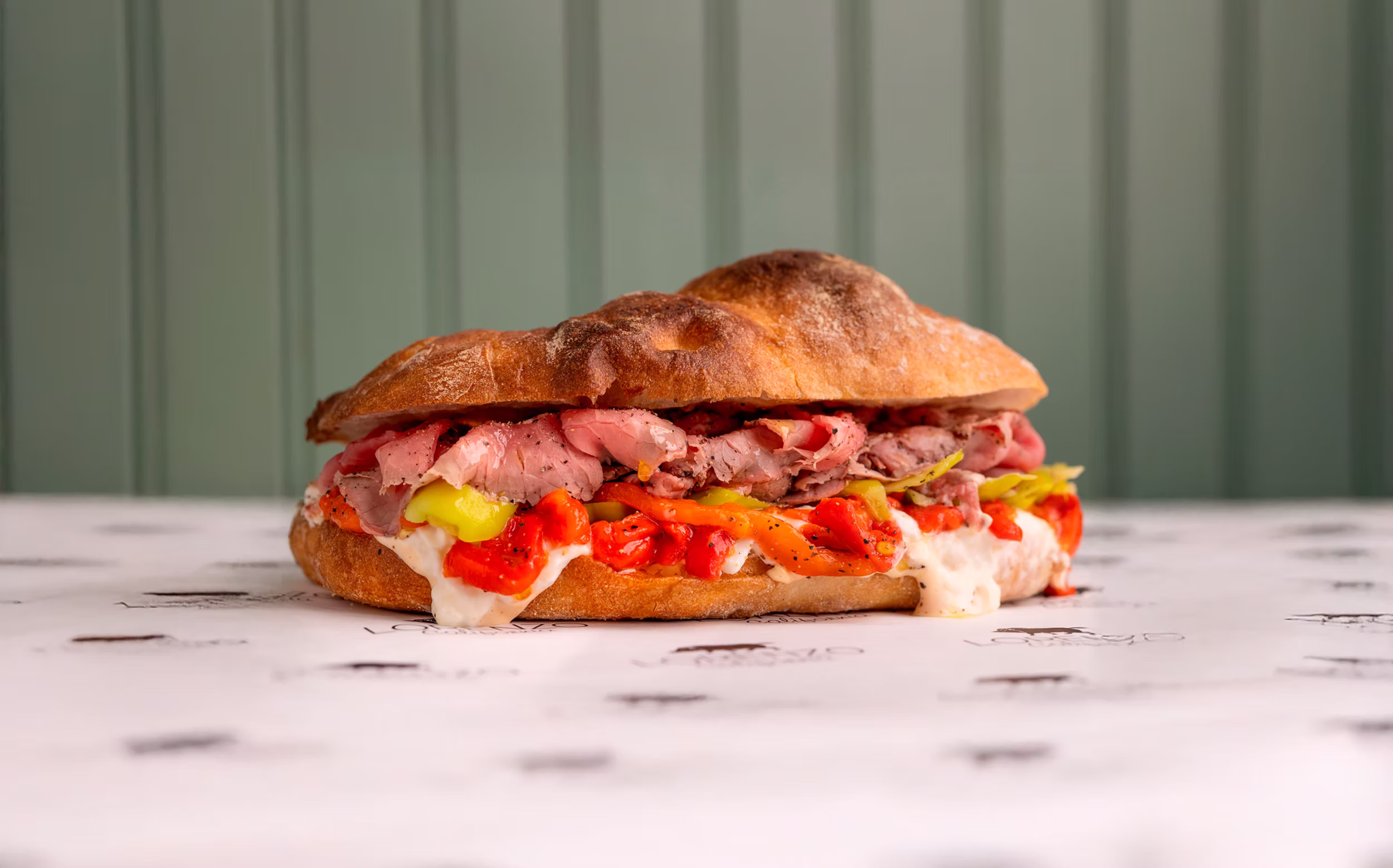 Fresh focaccia sandwich with roast beef, cheese and peppers
